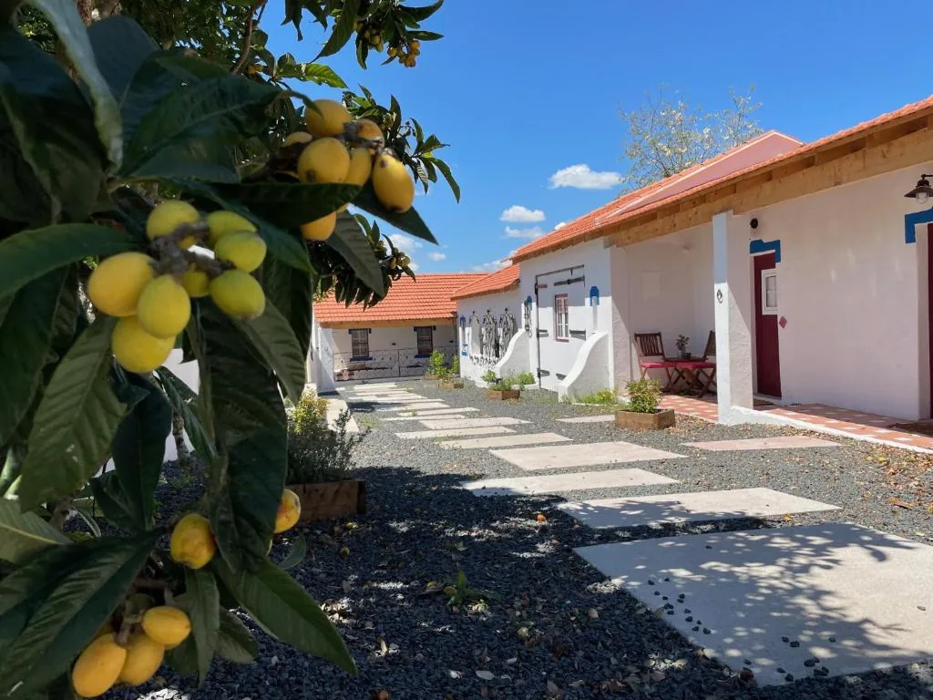 Pátio do Casal de Santanna visto entre folhas e fruta