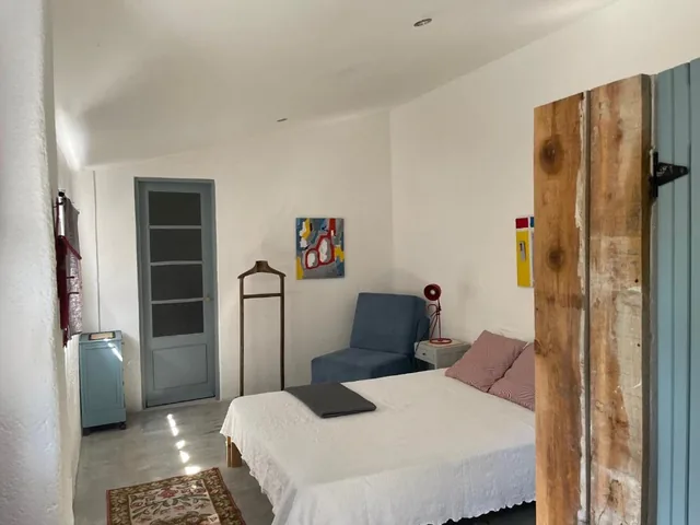 Quarto duplo com mobiliário simples e porta azul