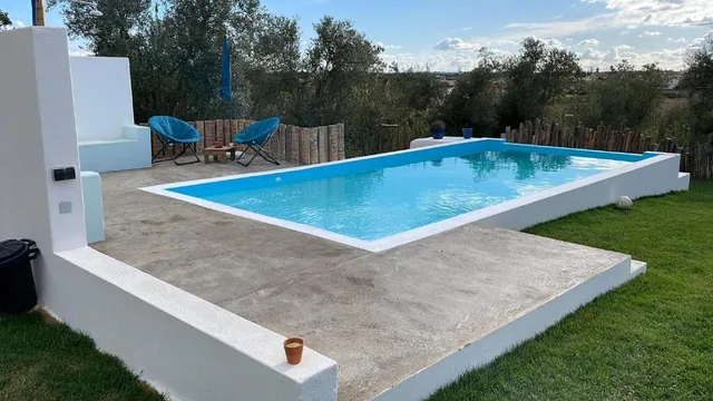 Piscina exterior rodeada pelo jardim